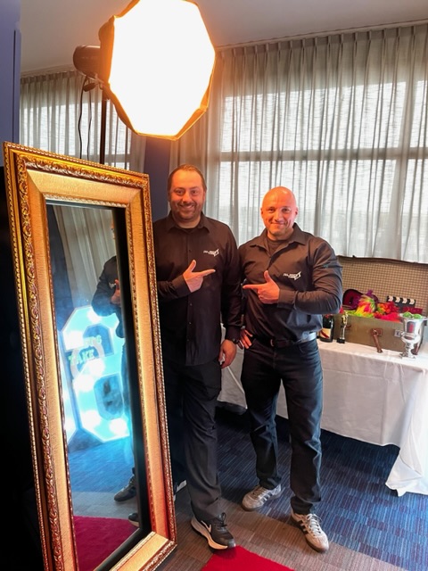 Two men and a selfie mirror at a party in Shrewsbury